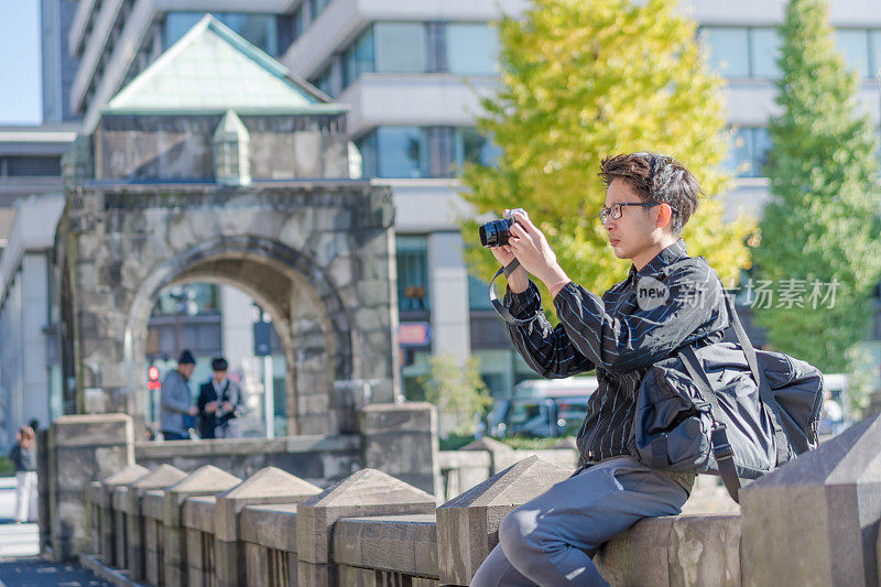 年轻的亚洲男子和日本朋友寻找旅游地点使用手机和花时间在亚洲旅行