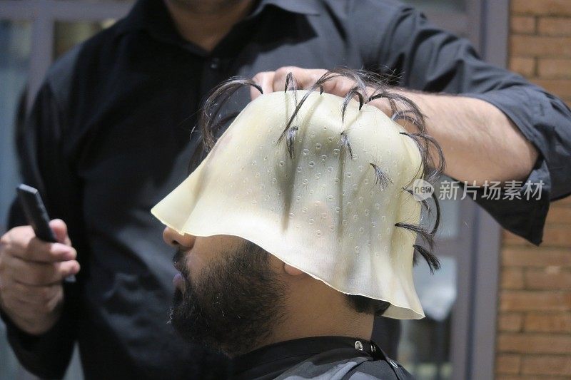 印度德里，发型师，发廊里的印度男子，戴着高亮帽