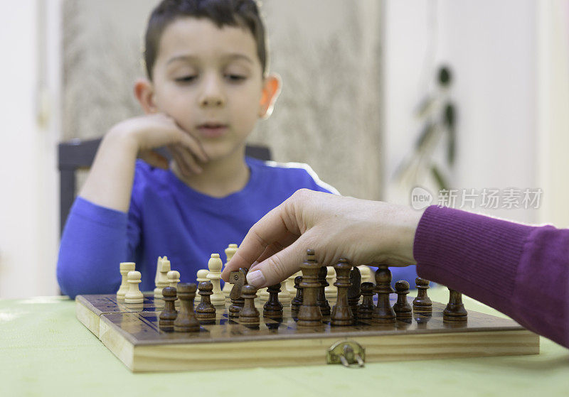 聪明的孩子下棋的时候能集中精神和思考