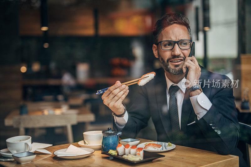 在寿司店打电话的男人