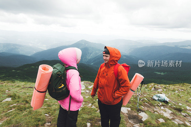 一对年轻的背包客在山里徒步旅行