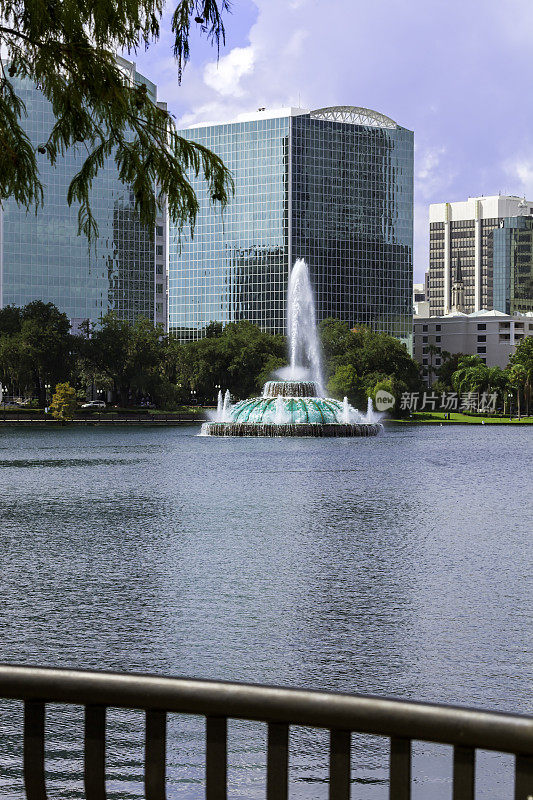 玻璃覆盖的摩天大楼和高层公寓俯瞰着佛罗里达州奥兰多市Eola湖公园著名的喷泉