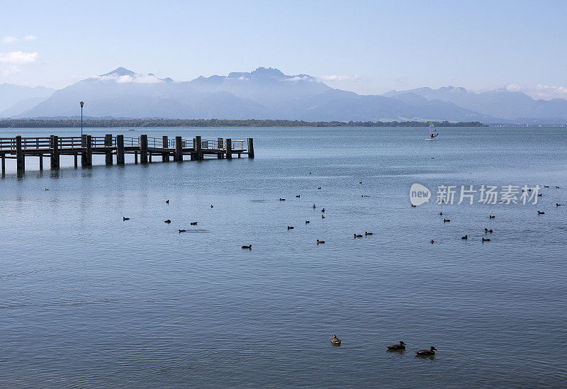 木制的防波堤通向基姆湖，背景是德国的阿尔卑斯山