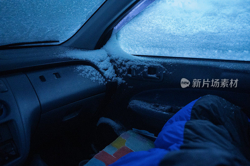 汽车观点。睡在车里。在积雪覆盖的路上开车，先下一场雪。