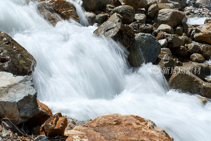 一条河流在山区、陡峭的河岸、多岩石的河床和瀑布中奔流