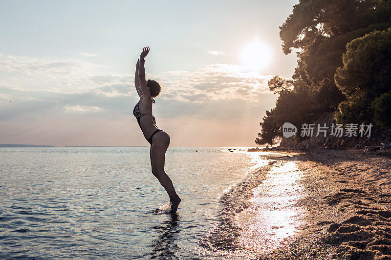 年轻女子准备跳进海里