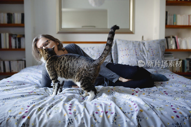 一个女人和一只猫躺在床上