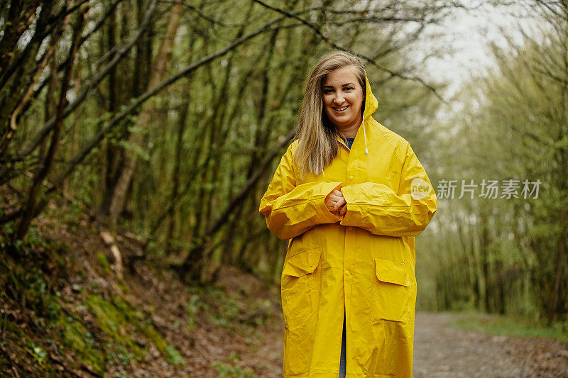 雨中穿着黄色雨衣的年轻女子