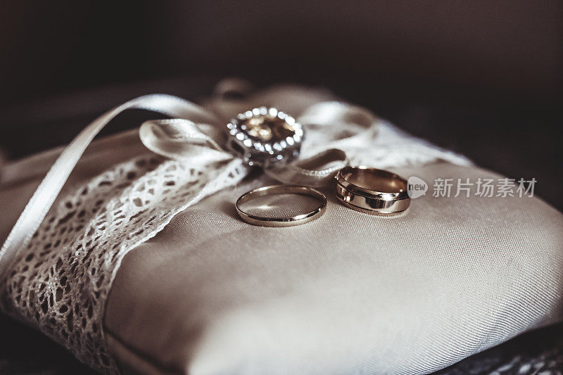 两个结婚戒指绑在一个枕头上