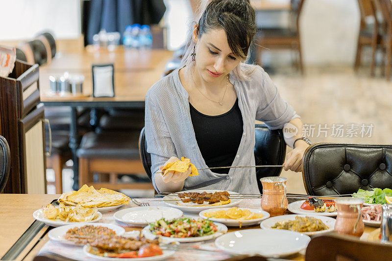 年轻女子在吃羊肉串