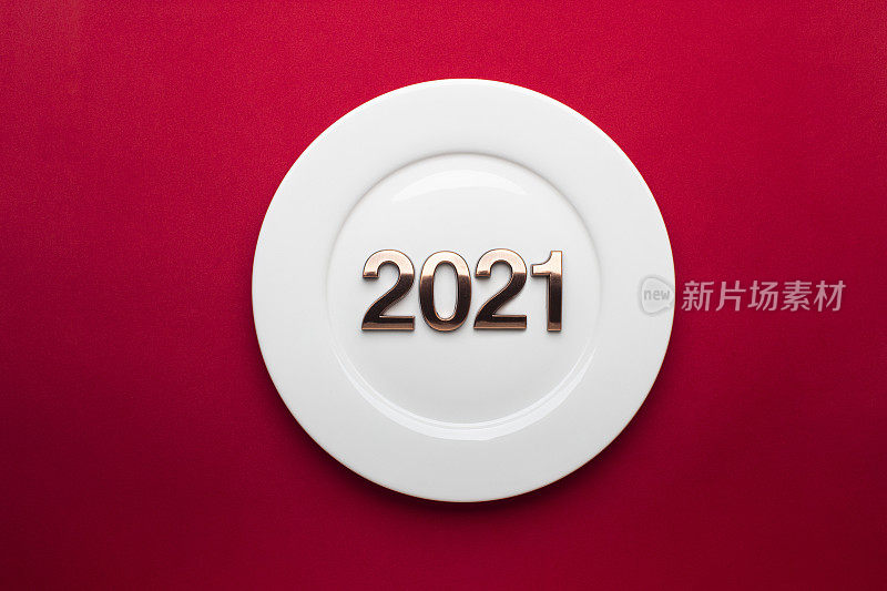 红色背景白色盘子的2021年新年快乐。