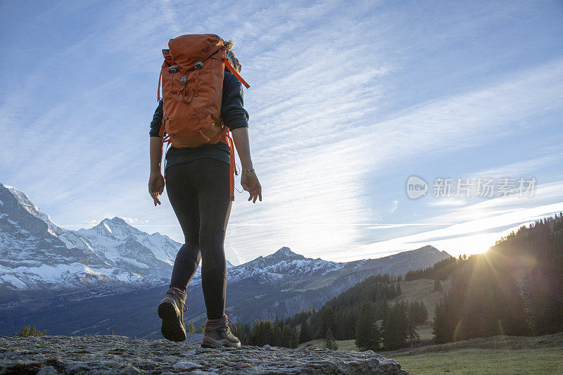 日出时分，女徒步旅行者在山脊上休息