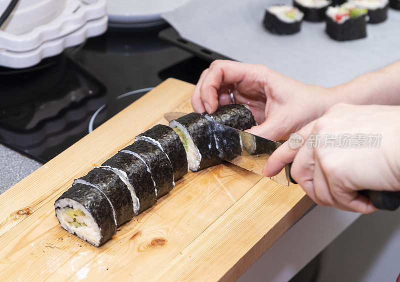 女孩的手正在准备寿司卷。日本料理在家。