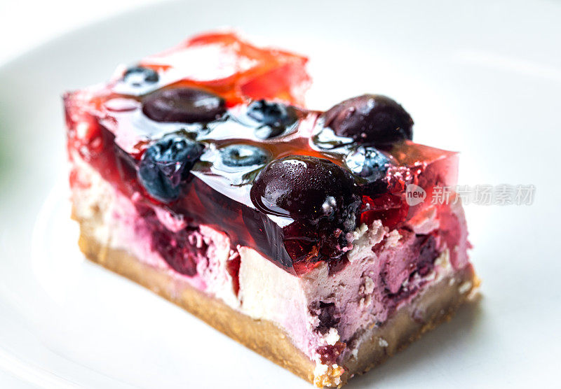 自制芝士蛋糕，白色盘子里有樱桃和蓝莓。