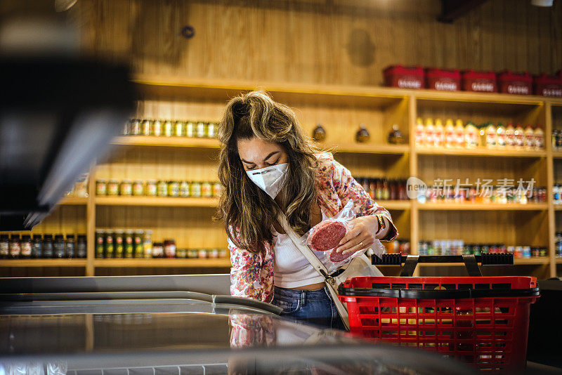 在肉类市场选购肉类的女人。戴防毒面具