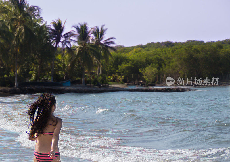 快乐的年轻女子在海滩上奔跑