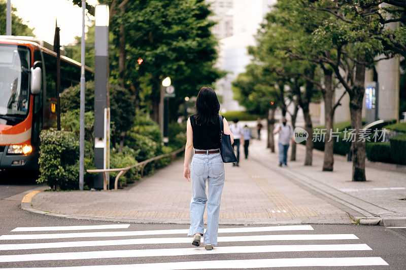 女人在街上行走的后视图