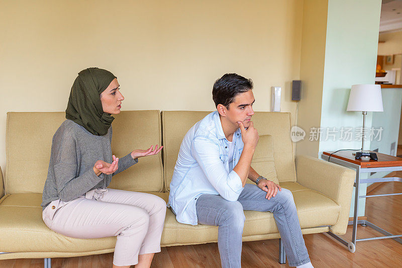 一对年轻夫妇在现代住宅的客厅里争吵。