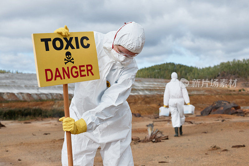 生态学家戴口罩，穿着防护服，用有毒危险区域标识区域