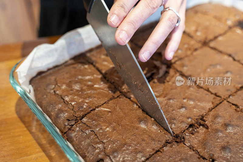 女人正在切一块巧克力蛋糕