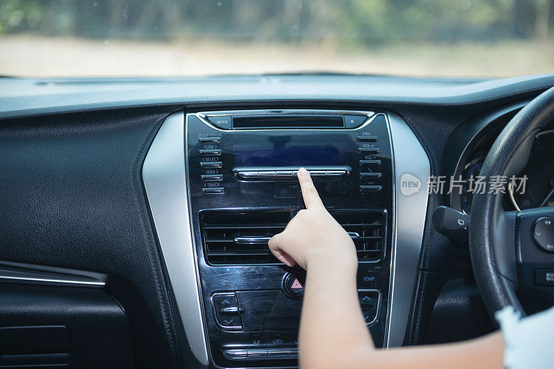 女人的手打开汽车空调系统，按钮仪表板上的汽车仪表板，汽车汽车空调汽车仪表板。广播特写镜头。一个女人在安装收音机。