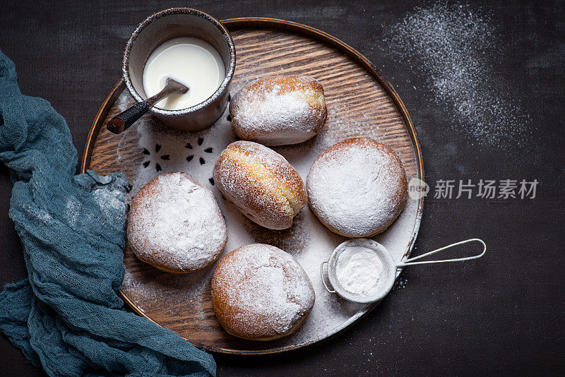 果酱甜甜圈，撒上糖粉和一杯牛奶