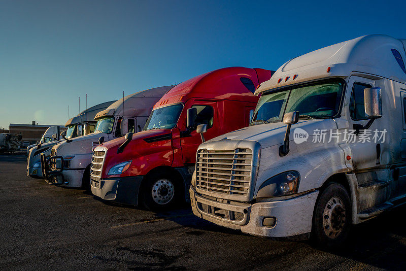 三辆红白相间的半卡车停在很多地方，准备在全国各地运送货物