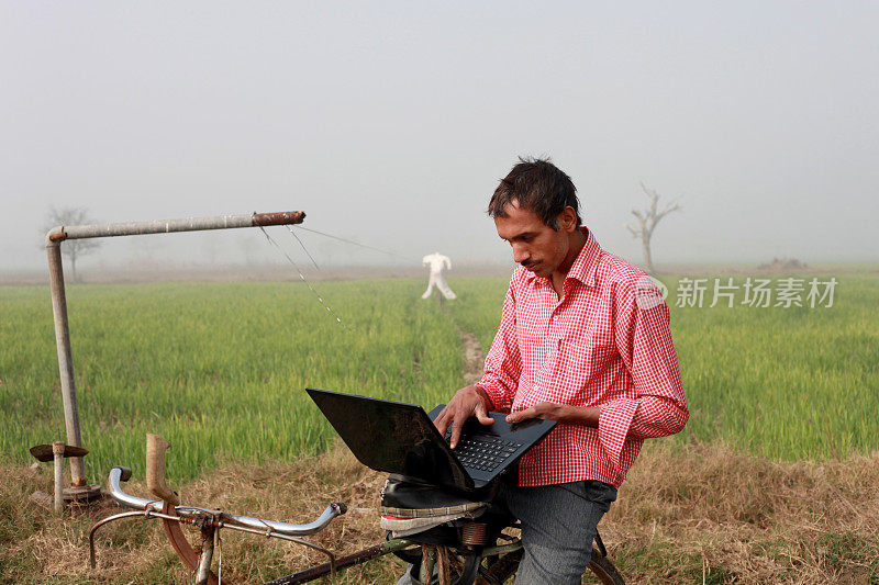农民骑自行车用笔记本电脑