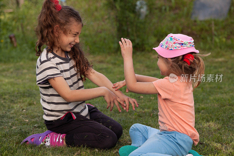 两个小女孩在公园的草坪上打架