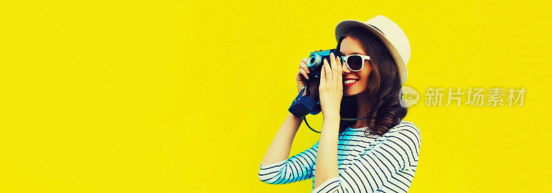 夏天的肖像快乐微笑的年轻女子摄影师与复古胶卷相机彩色黄色的背景