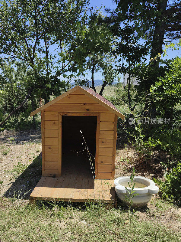 草地上空荡荡的棕色木狗屋