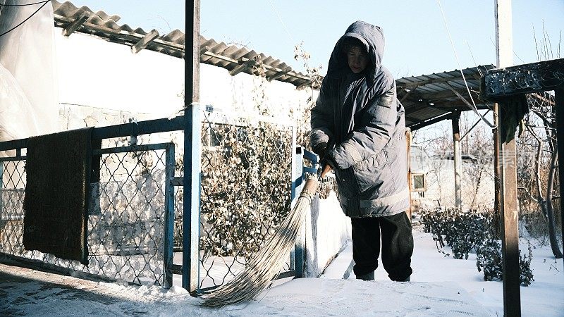 女人在后院扫雪