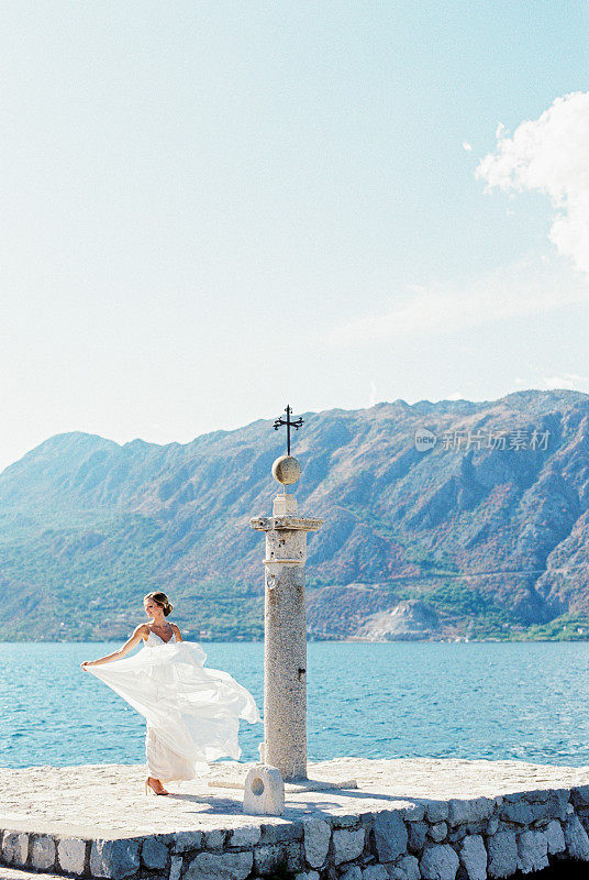 新娘在码头上握着飘逸的裙摆