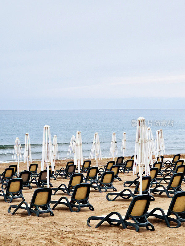 空旷的沙滩上有躺椅和遮阳伞