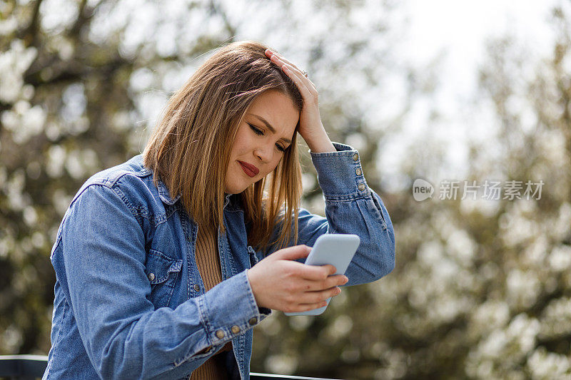 沮丧的年轻女子在智能手机上回复短信