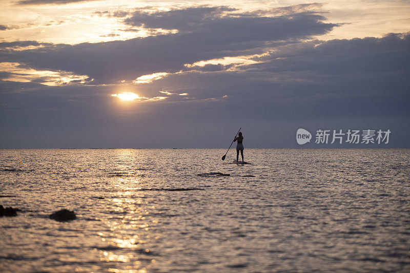 一个女人在一个站立式桨板上划了一个夏日