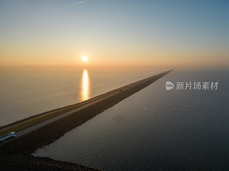荷兰发电:黎明时分，荷兰艾瑟尔湖26公里长的堤坝。