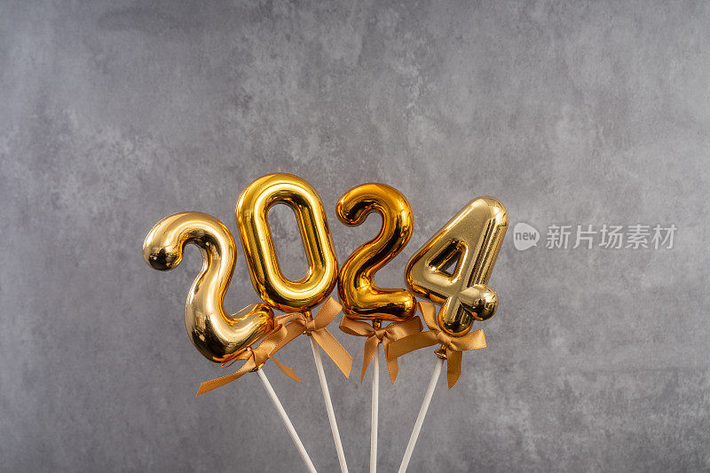 灰色混凝土墙背景上的2024年新年。