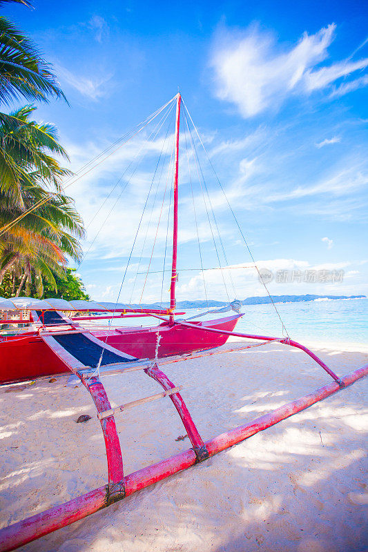 长滩岛白色沙滩上的一艘菲律宾红船