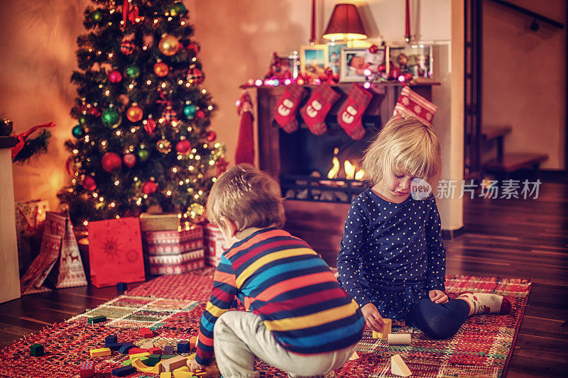 可爱的孩子们在圣诞树前玩耍