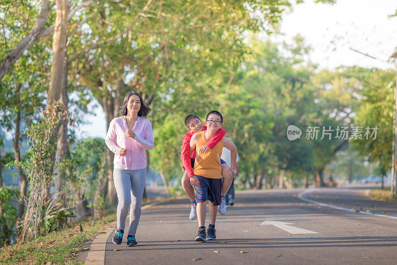 家庭运动快乐活跃的母亲和孩子在户外慢跑，在森林里跑步