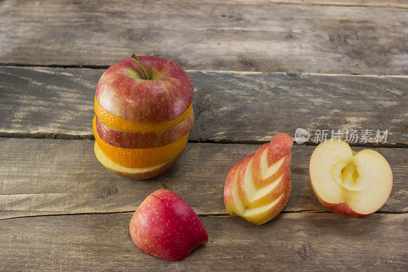 把成熟的苹果和橙子混合放在一张木桌上