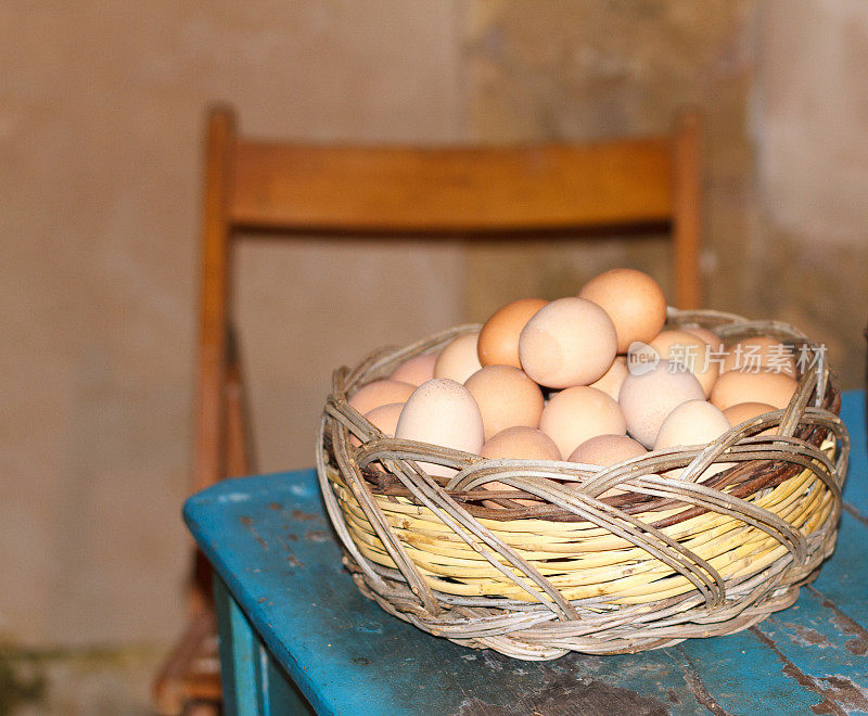 新鲜棕色鸡蛋，乡村篮子，老蓝桌子，意大利
