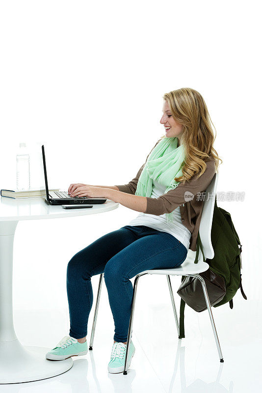微笑的学生坐在电脑上工作