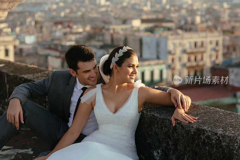 西班牙新娘和新郎在屋顶上凝视着这座城市