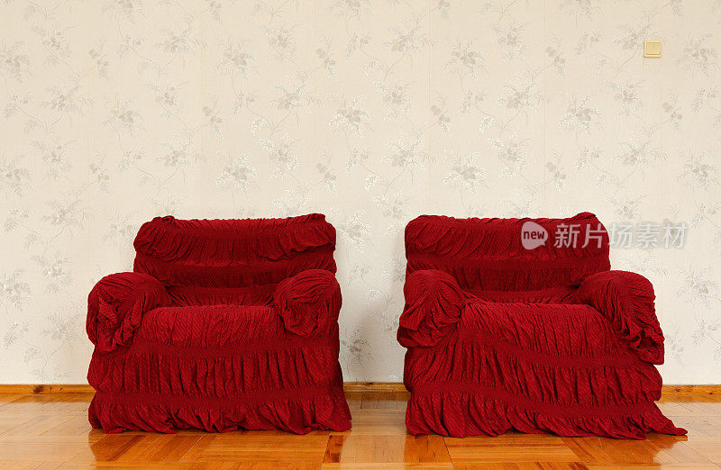 奇怪的一对，客厅里有两把旧的红色扶手椅