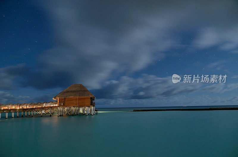 夜间热带泻湖上的水上度假别墅