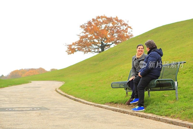 坐在公园里的情侣互相聊天