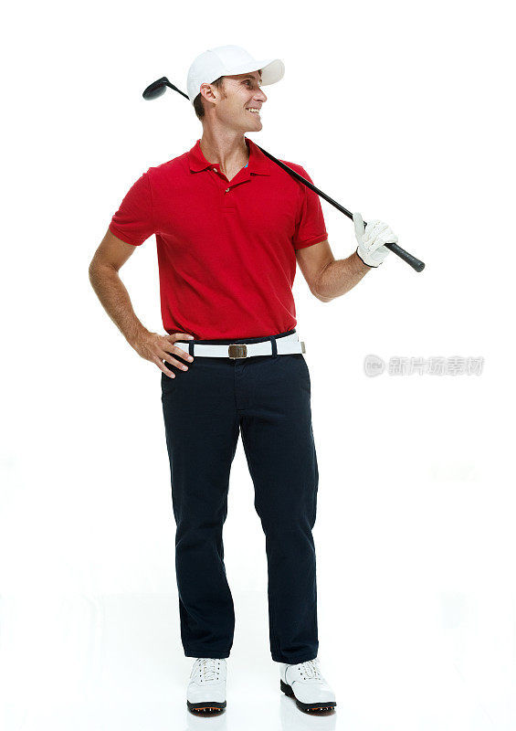 微笑的高尔夫球手拿着高尔夫球杆&看向别处
