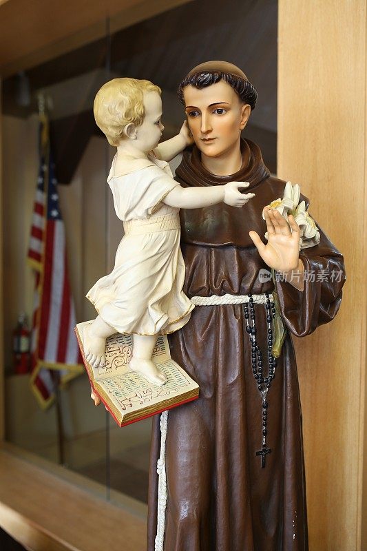 帕多瓦天主教圣安东尼雕像抱着婴儿耶稣，百合花